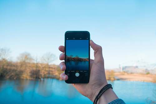 cell phone person showing photo of body of water computer